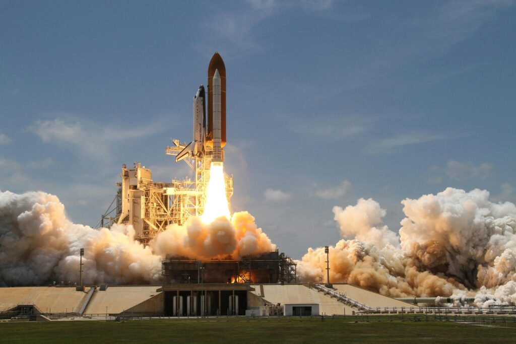 flight-sky-earth-space-2166 A NASA space shuttle launches with fiery liftoff, ascending into the sky amid plumes of smoke.